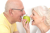 Senior couple with apple, healthy teeth concept