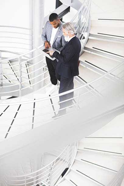 istock Business colleagues talking while standing by stairway 1141325880