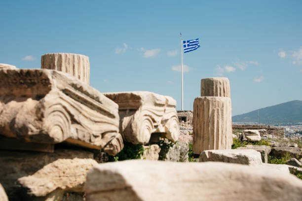 Ruins in the Acropolis and Greece flag in the backgorund