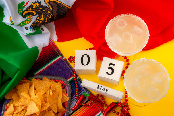 meksykańska fiesta i cinco de mayo temat koncepcyjny z kalendarzem bloku ustawionym na 5 maja, naszyjnik z koralików pieprzowych jalapeno, tradycyjny dywan lub serape, dwa kieliszki margarita, frytki i meksykańska flaga - glass jewelry necklace bead zdjęcia i obrazy z banku zdjęć