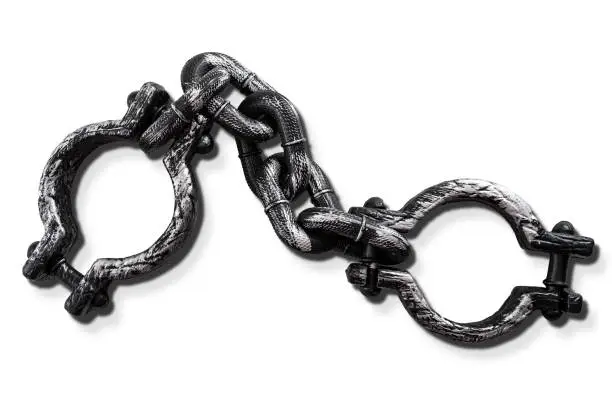 Photo of Slavery and bondage concept with strong steel shackles isolated on white background with a clip path cutout