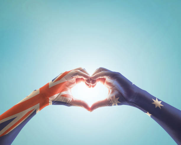 australia national flag  on people hands in heart shape on blue sky background for labour day and national holiday celebration - australia australia day celebration flag imagens e fotografias de stock