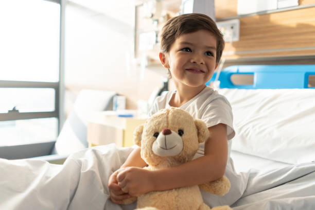 Close up of beautiful little boy hugging his teddy bear while looking away daydreaming Close up of beautiful little boy hugging his teddy bear while looking away daydreaming and smiling teddy bear photos stock pictures, royalty-free photos & images