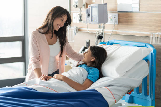 istock Beautiful young mom talking to her hospitalized daughter lying down on bed 1141330688