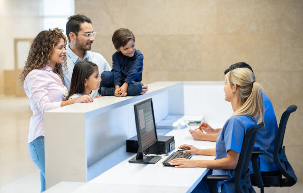 alegre familia latinoamericana registrarse para una cita con el médico en un centro médico todos sonriendo - nurse doctor healthcare and medicine latin american and hispanic ethnicity fotografías e imágenes de stock