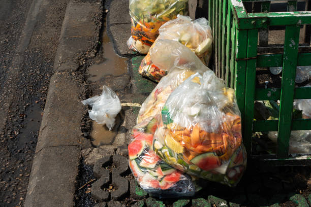 marnotrawienie żywności w plastikowych torbach na chodniku - garbage bag garbage bag food zdjęcia i obrazy z banku zdjęć