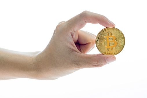 Fujian, China - May 30, 2018: Human hand holding bitcoin coin on white background. Bitcoin is virtual currency.