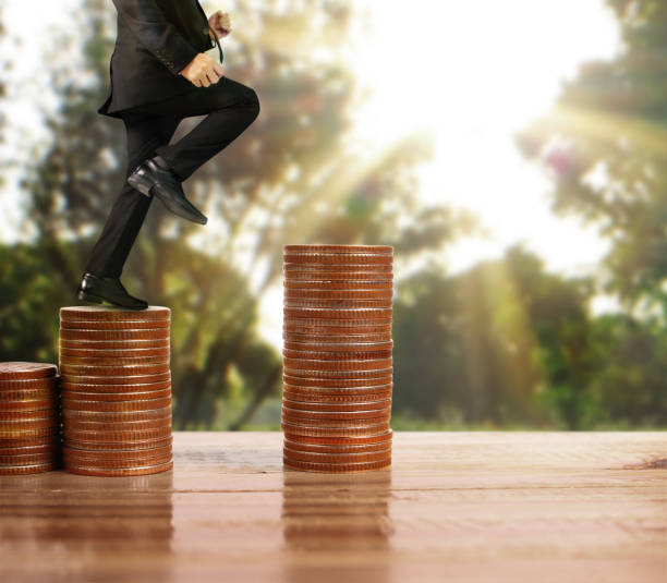 istock Businessman walk on stack of coins which grows success 1141335357