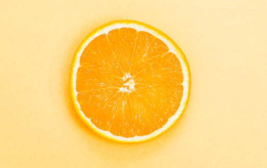 Orange slice on yellow background.