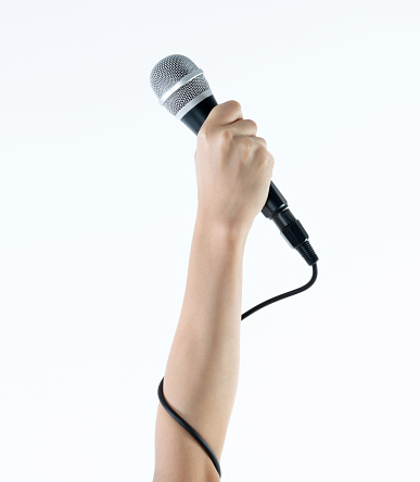 Woman hand holding a microphone on white background.