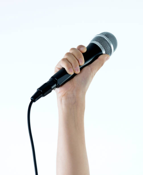 istock Woman hand holding a microphone on white background 1141337285