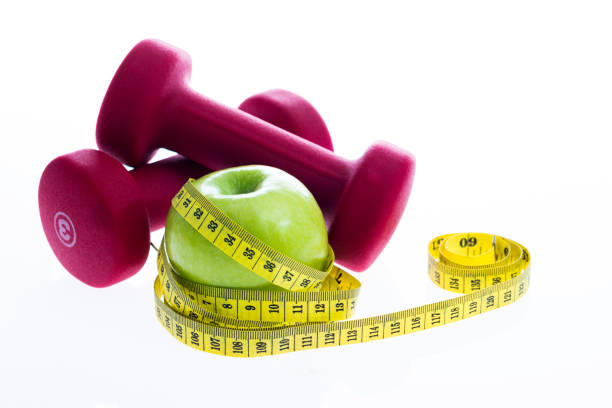 istock Green apple with a measuring tape and dumbbells 1141337328