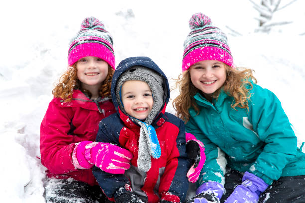 istock Three Children Smiling At Camera On Winter Day 1141338837