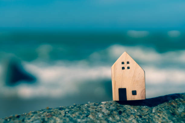 istock Closed up tiny home models on sand with sunlight and beach background. 1141342534