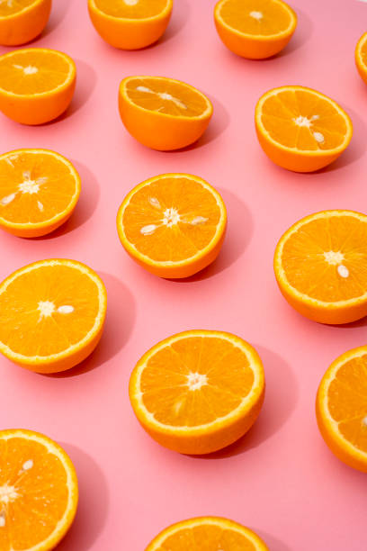 istock Orange juicy oranges split in half on pink 1141344986