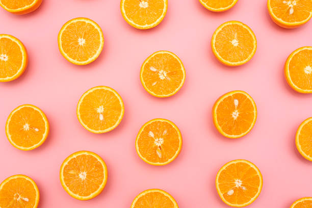 istock Orange juicy oranges split in half on pink 1141345018