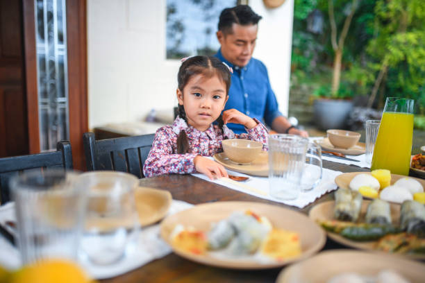 istock Cute girl sitting with father at dining table 1141352357
