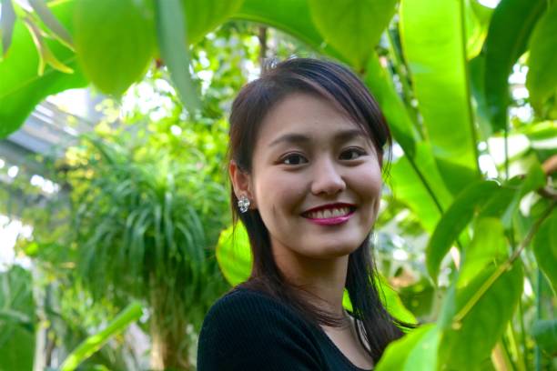 istock Young woman smiling at park 1141352658