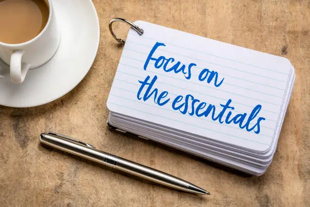 Focus on the essentials  - reminder on a stack of  index cards with a cup of coffee