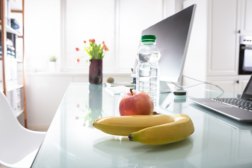 Apple And Laptop On Desk In Office