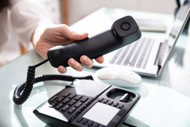 istock Woman's Hand Dialing Telephone Number To Make Phone Call 1141353568