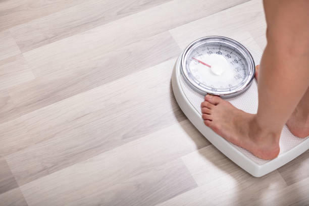 istock Woman Standing On Weighting Scale 1141353724