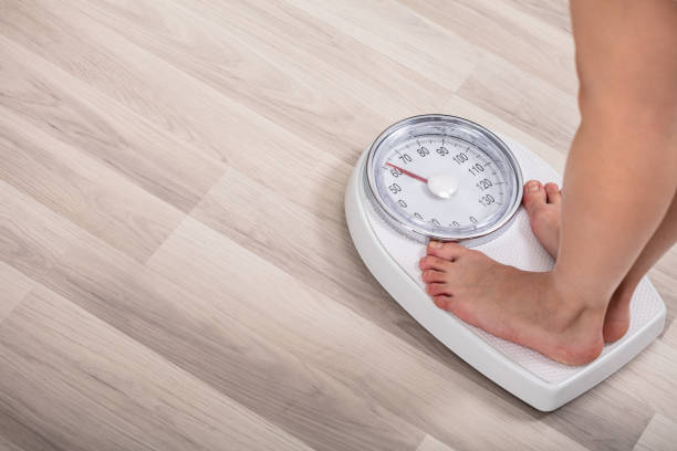 istock Woman Standing On Weighting Scale 1141353729