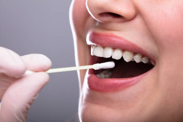 istock Dentist's Hand Taking Saliva Test From Woman's Mouth 1141353786