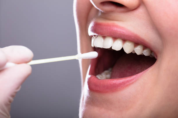 istock Dentist's Hand Taking Saliva Test From Woman's Mouth 1141353787