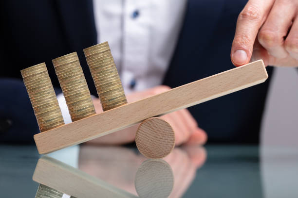 istock Businessman Balancing Stacked Coins With Finger 1141354709