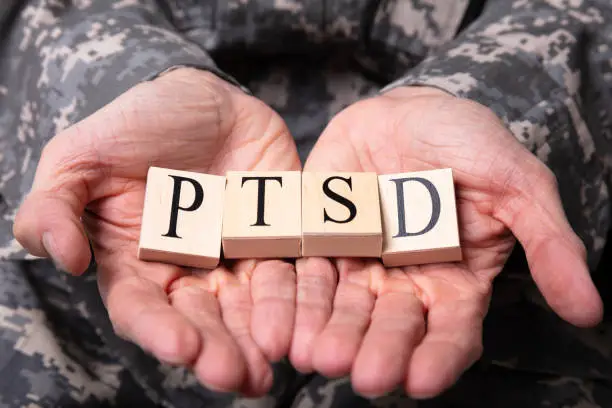 Photo of Male Soldier Holding Wooden Cubes With PTSD Text