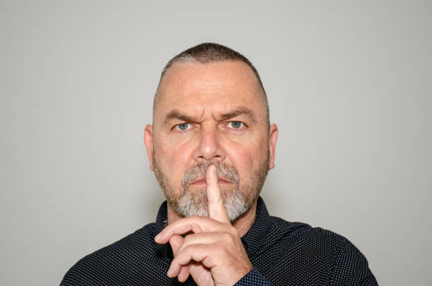 istock Man making a hush gesture with finger to lips 1141354999