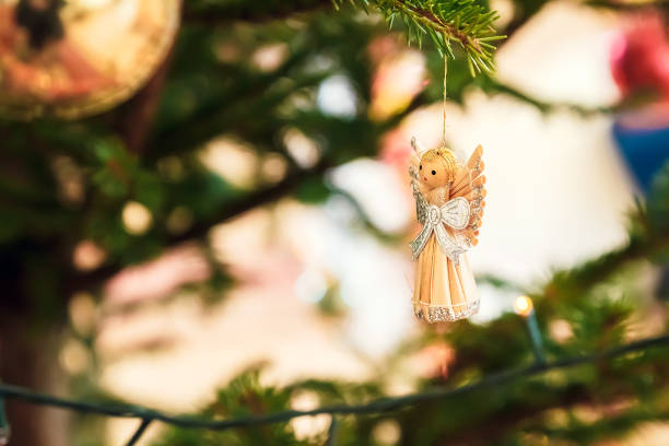 Christmas angel on christmas tree branch, lights hanging in a tree