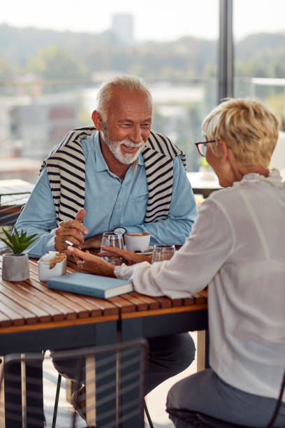 istock Senior Couple Enjoying Cappuccino And Using Smart Phone In Rooftop Cafe 1141360203