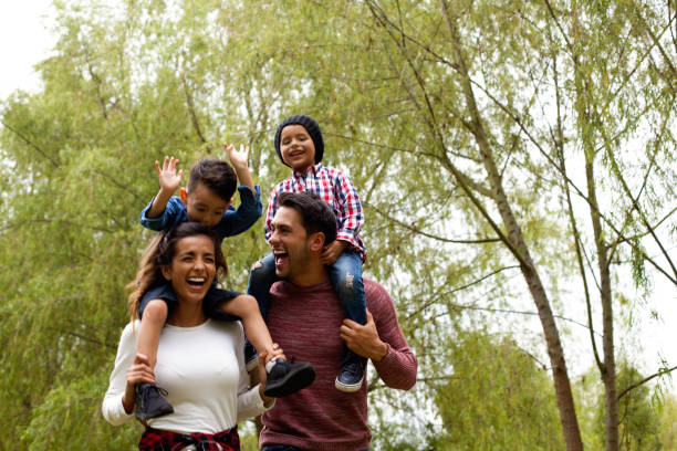 Family has fun playing in the field Family formed by parents and children of latin ethnicity of different ages have fun playing in the field public park photos stock pictures, royalty-free photos & images