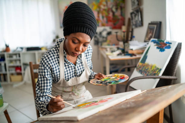 istock Young afro woman drawing 1141361526
