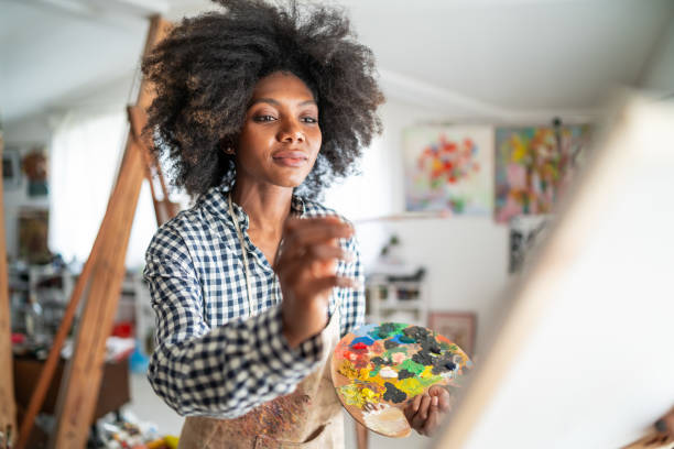 istock Young afro woman drawing 1141361528