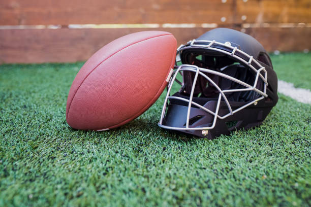 istock Rugby helmet with ball on green grass 1141362575