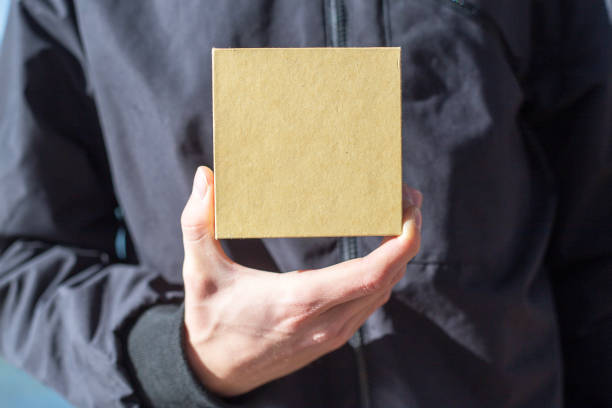 istock Young man holding a gift box in his hands 1141362758