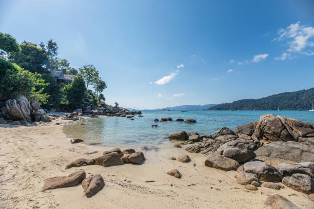 istock Rocks on coastline with resort on hill at Lipe 1141362992