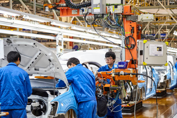 workers who install and install cars on the shanghai volkswagen factory assembly line are busy. - editorial land vehicle construction equipment built structure imagens e fotografias de stock
