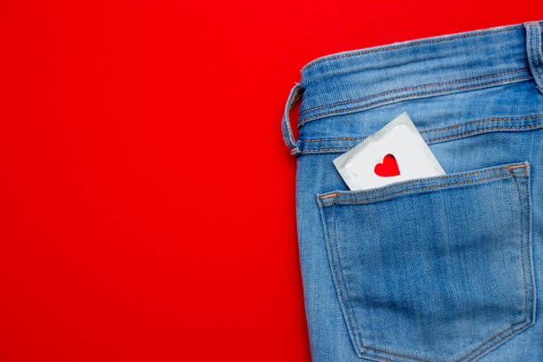un préservatif dans une poche de jeans. sex safe - sex condom jeans horizontal photos et images de collection