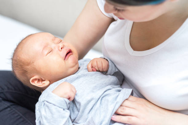 newborn is crying because of colic pain - colic imagens e fotografias de stock