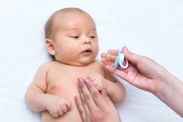 istock mother giving a pacifier to her newborn son 1141366118
