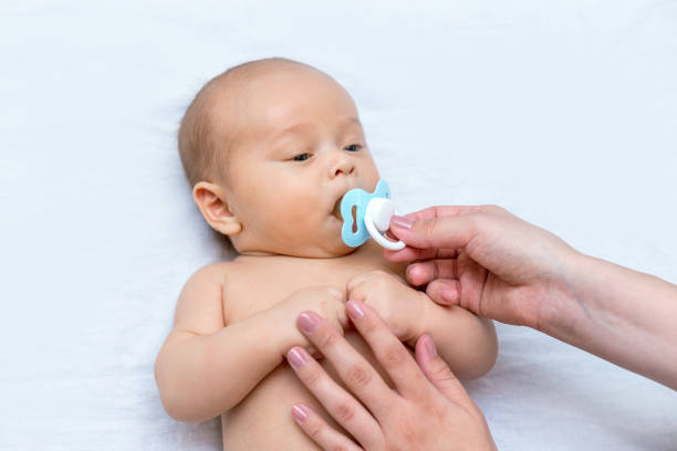 istock mother giving a pacifier to her newborn son 1141366129