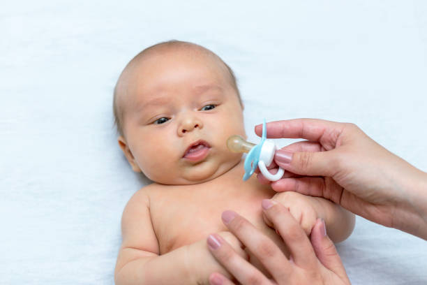istock mother giving a pacifier to her newborn son 1141366154