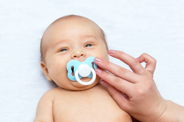 istock mother giving a pacifier to her newborn son 1141366170