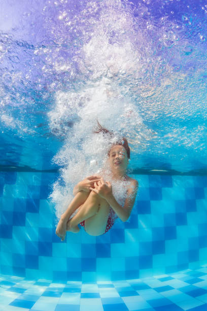 istock Funny girl dive in swimming pool 1141368446