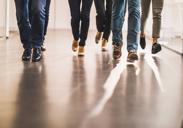 istock Group of unrecognizable colleagues running through hallway. 1141368588