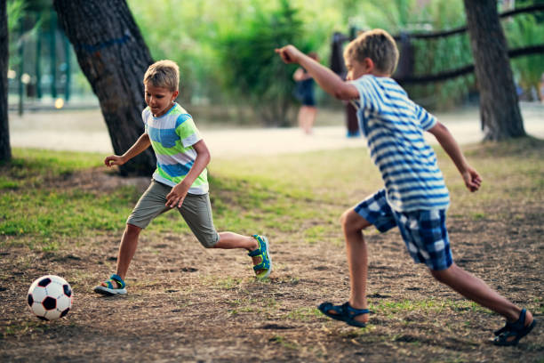 istock Kids playing soccer in the park. 1141370017